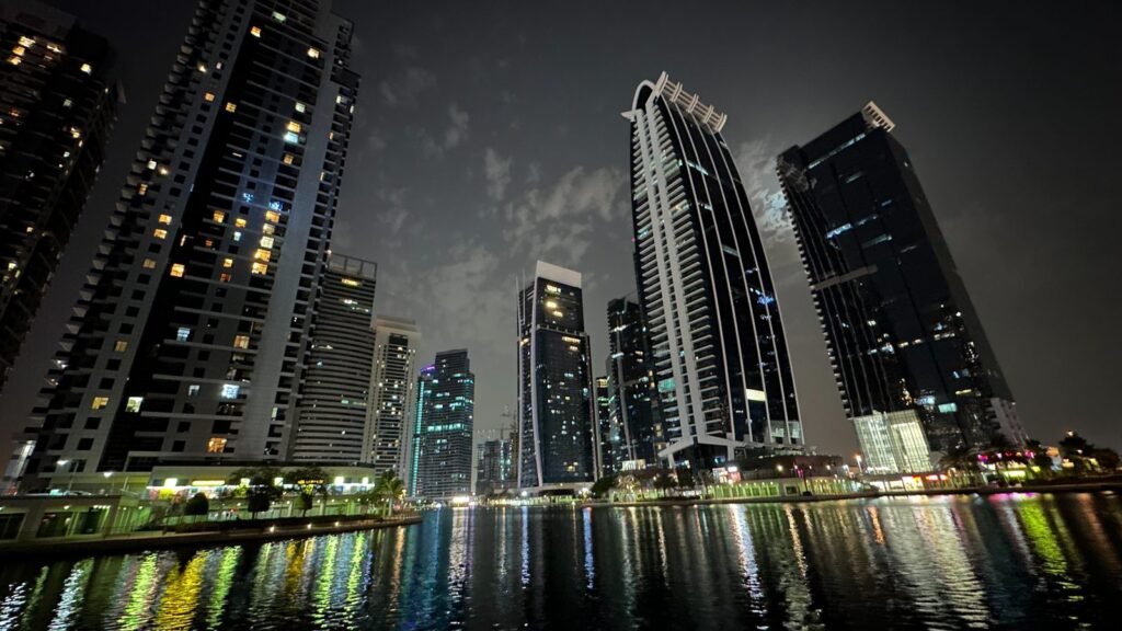 Jumeirah Lake Towers DMCC free zone Dubai at night, illustrating free zone corporate tax compliance cost 2026